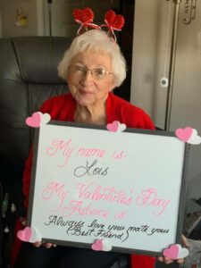 Old Lady wearing a red headband, holding a whiteboard with words on it