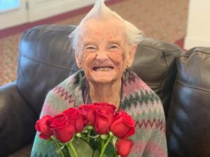 Old lady holding roses and smiling